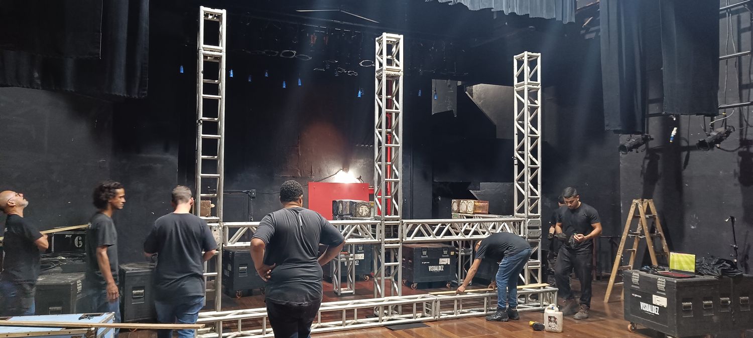 Equipe montando estrutura de treliças no palco